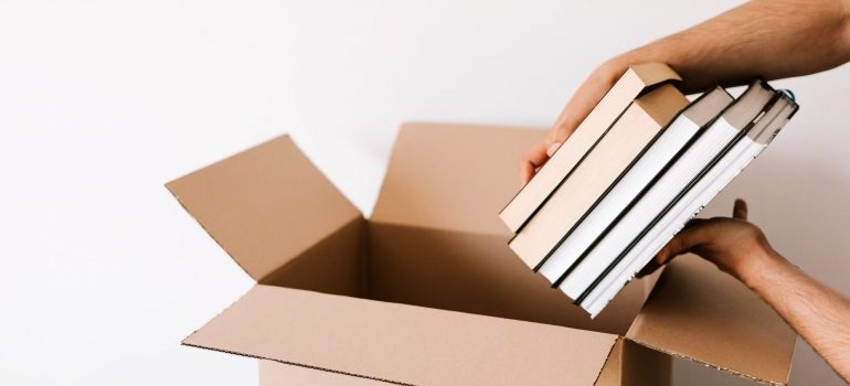 A person putting books in a box.