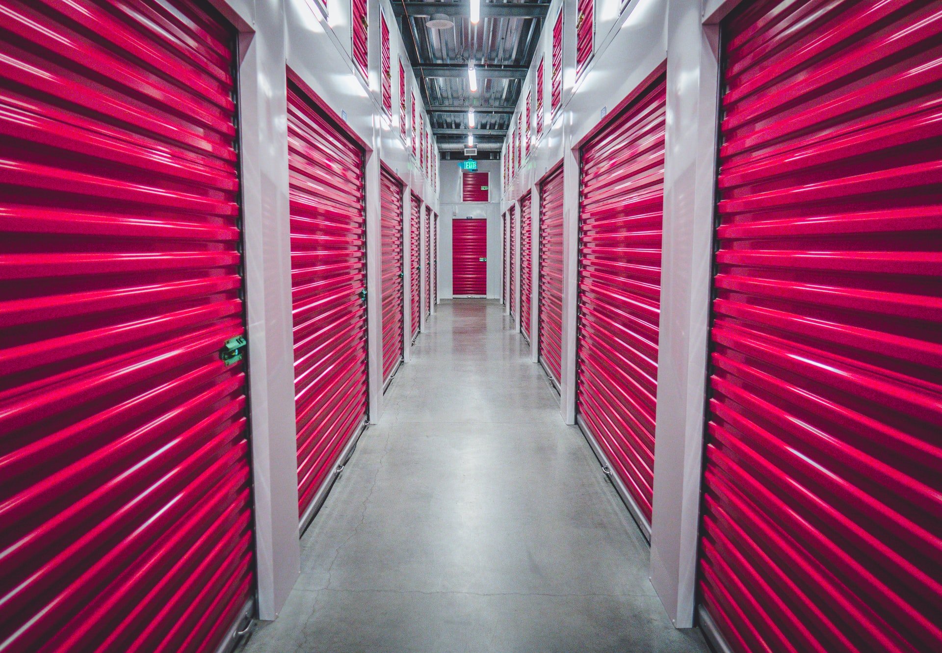 Two rows of storage units with bright red doors.