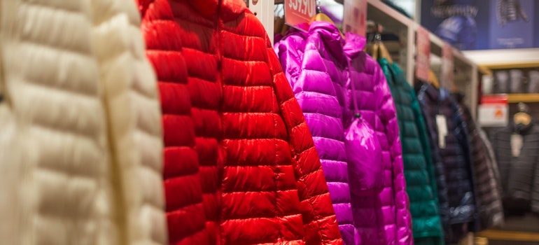 a bunch of colorful jackets in a boutique