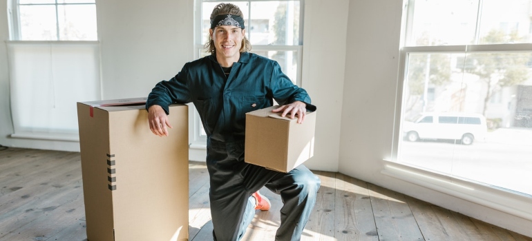 Mover smiling and holding a box