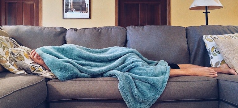 A person is taking a nap on the sofa.