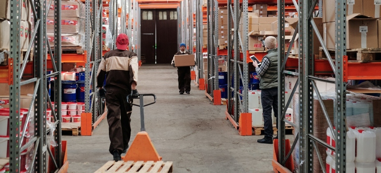 Three workers in a warehouse- using storage units helps you cope with the 4Ds of life