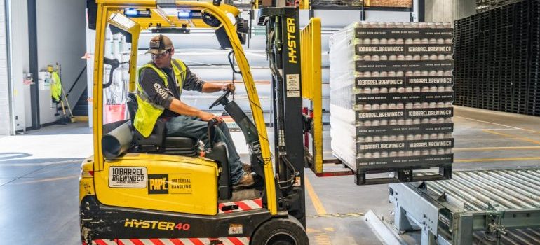 A man using a forklift in climate controlled storage Northern Virginia recommends
