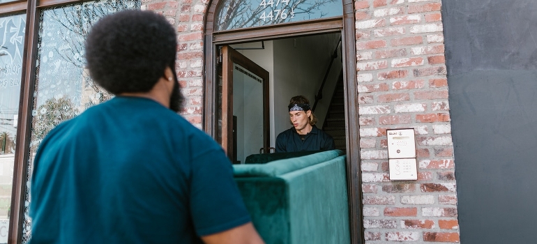 movers providing senior moving services by moving a couch 