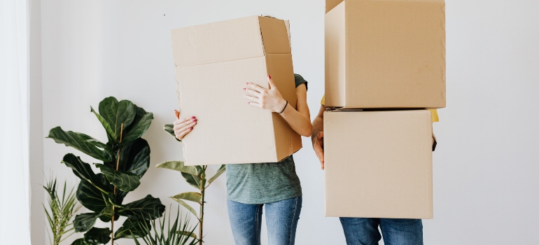 man and woman behind boxes thinking about moving in with your partner