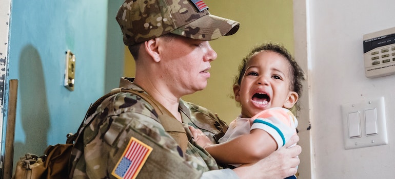 A US military soldier holding his kid and thinking about different types of storage