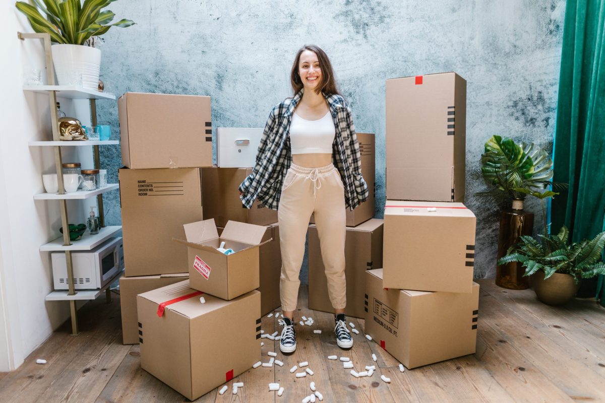 a woman standing next to a pile of boxes
