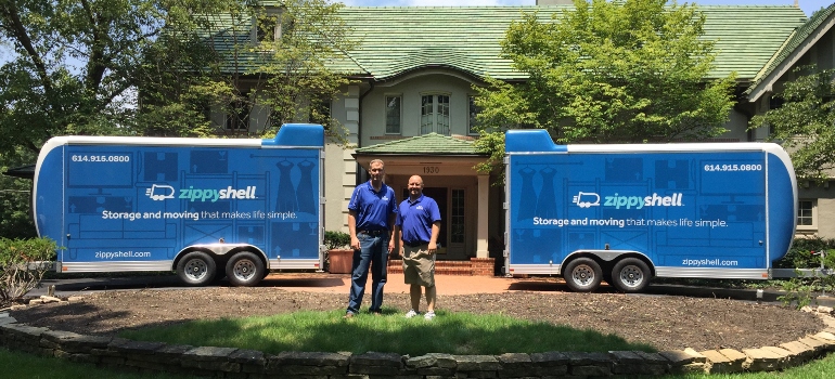two men standing in front of portable storage