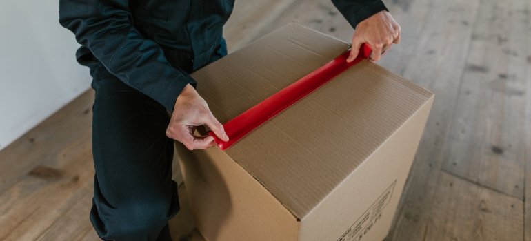 a mover taping a box