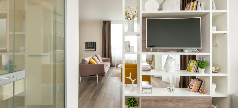A modern, well-organized living room with a large TV and bookshelf, highlighting a minimalist and clean space.